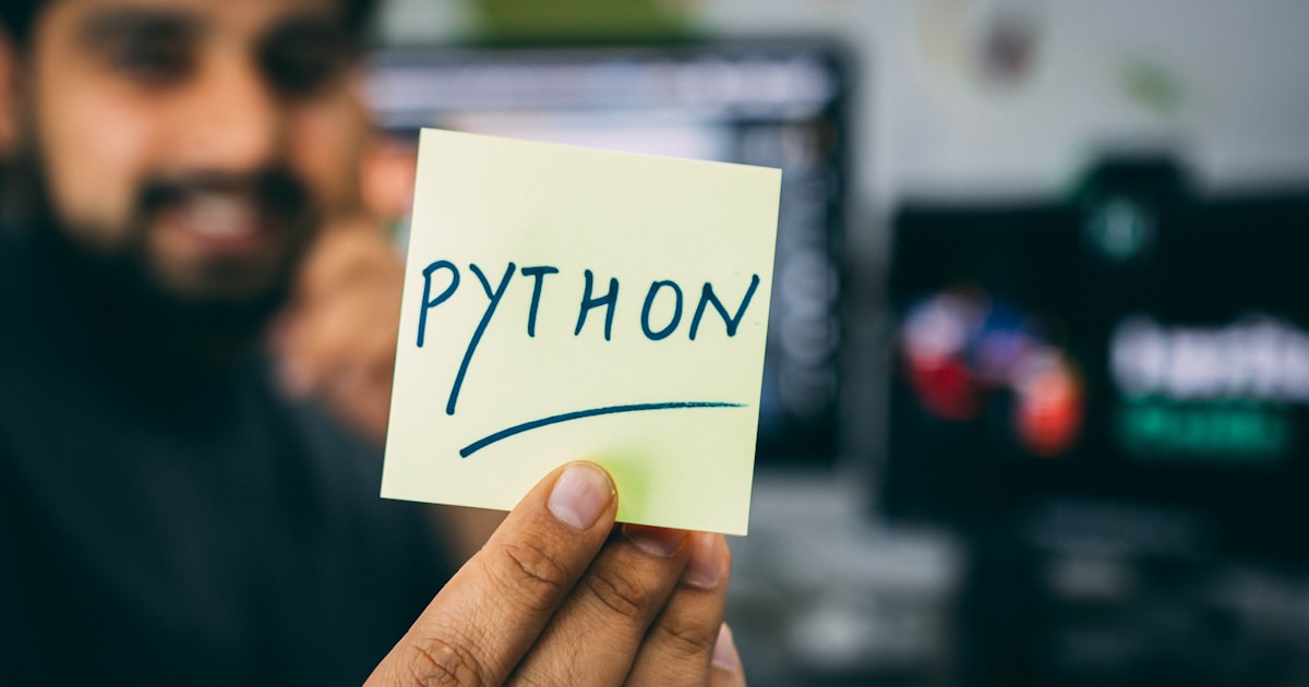 A developer holding a note that reads Python