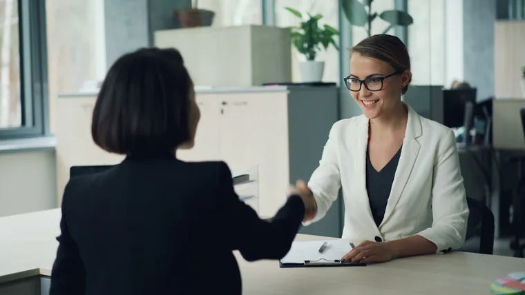 A candidate and a hiring manager shaking hands