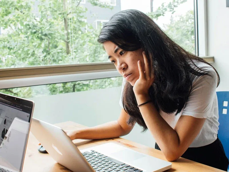 A woman sitting in front of a laptop